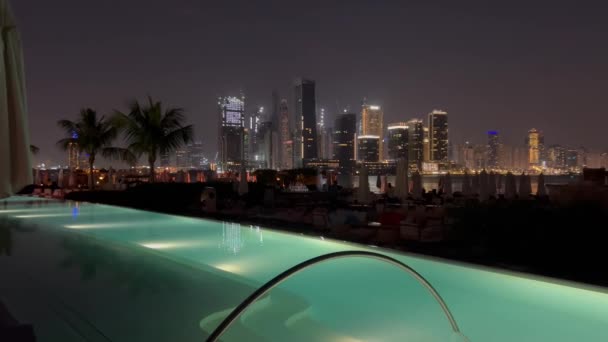 迪拜棕榈朱美拉岛夜景 摩天大楼在晚上 漂亮的游泳池和海滩 迪拜码头在夜间 从棕榈胡梅拉赫群岛的湖中 灯光明亮的建筑物和反光映照 奢侈品 — 图库视频影像