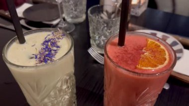 Lüks restoranda yemek masası. Şarap bardakları ve peçetelerle dolu restoran masası. Taze meyve suyu. Yapay zeka üretildi. Meyve püresi. Sağlıklı yeşil smoothie ya da taze sallama. 