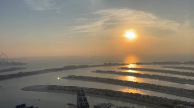 Dubai Palm Jumeirah adasının havadan görünüşü, Birleşik Arap Emirlikleri. AURA gökyüzü barında dinlenen turistler, Palm Jumeirah 'da dünyanın en yüksek 360 derecelik sonsuz havuzu Dubai Marina ufuk çizgisine bakıyor.