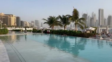 Dubai Palm Jumeirah adalarının manzarası. Sahile yakın lüks havuzlar. Dubai Jumeirah plajı ve BAE 'de Marina gökdelenleri. Arka planda Marina ve şehir merkezindeki gökdelenlerin bulunduğu Palm Jumeirah binaları.