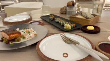 Suşi ve balığın yakın plan çekimi. Servis tabağında somon. Tabakta yemek, masada yemek, lezzetli yiyecekler, lezzetli yiyecekler. Suşi seti ve suşi. Restoranda hizmet etmek. 