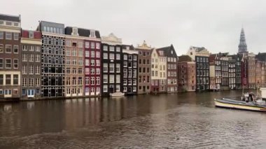 Amsterdam şehir merkezi - Amstel nehri, eski evler ve bir köprü. Meşhur Amsterdam şehrinin güzel manzarası. Avrupa 'ya seyahat. Hollanda, Hollanda. Geleneksel Hollanda eski evleri. Amsterdam Bisikletleri 
