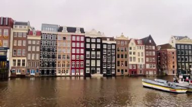 Amsterdam şehir merkezi - Amstel nehri, eski evler ve bir köprü. Meşhur Amsterdam şehrinin güzel manzarası. Avrupa 'ya seyahat. Hollanda, Hollanda. Geleneksel Hollanda eski evleri. Amsterdam Bisikletleri 