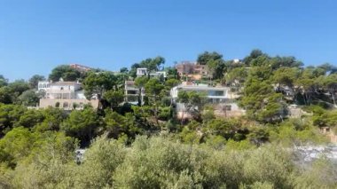 Palma de Majorca, İspanya - 7 Temmuz 2025 Santa Ponsa turizm merkezi. Santa Ponsa kıyı şeridi boyunca otelleri gösteriyor. Balear Adası 'ndaki mimari binalar. Daireler, sahildeki evler.