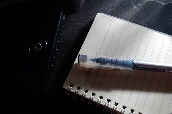 pen and note on black background
