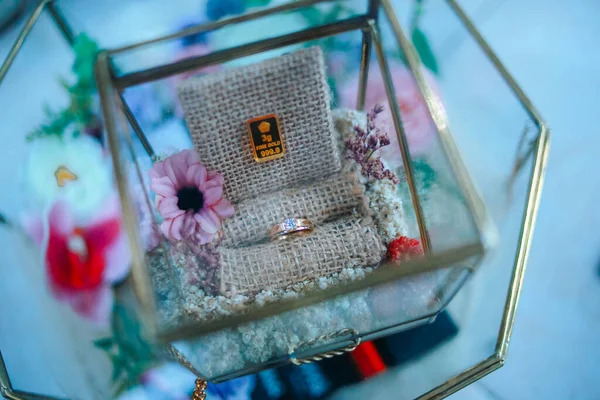 rings and gold in a transparent box decorated with flowers