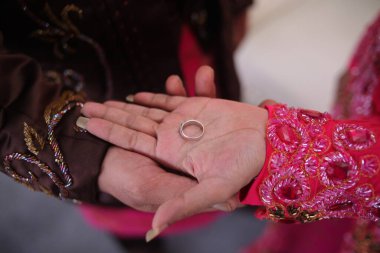 Gelin ve damadın ellerinde bir yüzük.