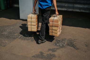 Pirinç kutusu taşıyan bir adamın arkadan görünüşü
