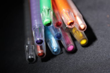 Siyah arkaplandaki çeşitli renkli kalemler.