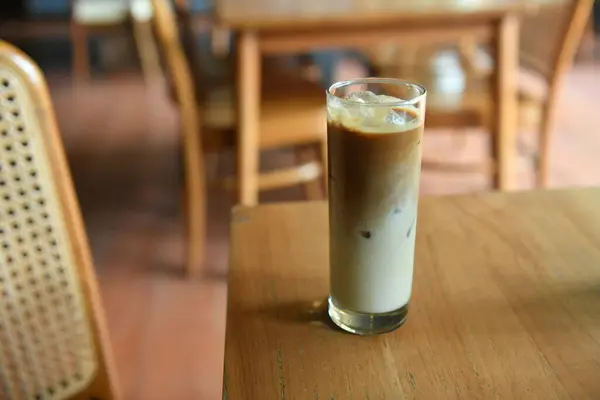 Iced coffee milk with palm sugar on wooden table.
