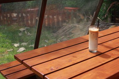 Palmiye şekerli buzlu sütlü kahve ve ahşap masada saman..