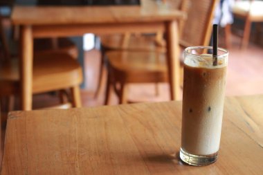 Palmiye şekerli buzlu sütlü kahve ve ahşap masada saman..