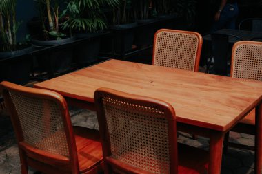 Tahta masalar, sandalyeler, boş masalar, boş alanlar.