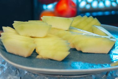 Buzlu bir tabakta ballı meyve dilimleri.