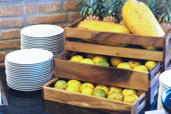 stock image oranges, papaya and pineapple on a wooden shelf