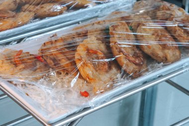 Beyaz tabakta Bakwan. Bakwan: Endonezya 'da yaygın olarak bulunan sebze ve buğday unundan yapılmış, plastik ambalajla kaplı bir tepside.