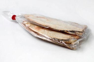 Beyaz arka planda plastik içinde tuzlanmış balık, makale için iyi.