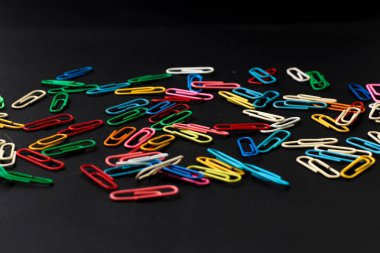 Siyah arkaplanda izole edilmiş renkli ataçlar