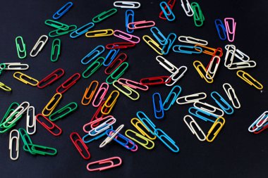 Siyah arkaplanda izole edilmiş renkli ataçlar