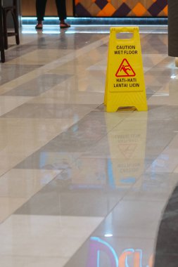 Dikkat ıslak tabela. Binada ıslak zemin uyarısı gösteren sarı işaret