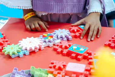 Plastikten yapılmış bulmaca bloklarıyla oynayan çocukların ellerini kapatın.