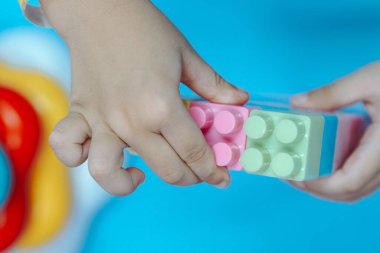 Plastikten yapılmış bulmaca bloklarıyla oynayan çocukların ellerini kapatın.