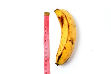 Yellow banana with measurement tape, Men penis size concept. Flat lay, top view, copy space.