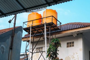 Düşük açılı portakal suyu mavi sabah gökyüzünün altında büyük bir tank.