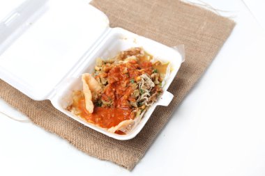 Endonezya usulü pirinç lapası (Bubur Ayam) ve doğranmış tavuk, kek. Krakerler, plastik kap içinde, yemek tarifi veya makale için iyi, sağlıklı paketler için değil.