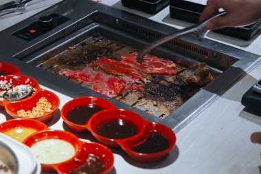 Japon usulü ızgara için çiğ et dilimi, yakiniku. Et ocakta pişiyor..