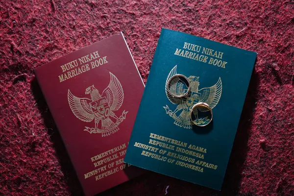 stock image Marriage book, Indonesian official marriage certificate which is legal proof of the existence of a marriage. Issued by Ministry of Religious Affairs, and a pairs of rings