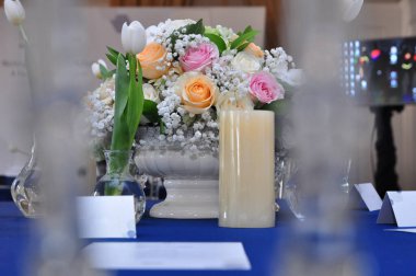 Masanın üzerinde gerçek çiçek buketi ve mumlar, seçici odaklanma.