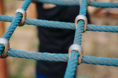 rope hemp net connected in a wooden frame by means of metal stainless steel connectors. it is an attraction for children on the playground clipart