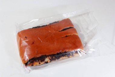 Çikolata ve süt dolu ekmek, plastik ambalajda, beyaz arka planda izole edilmiş, yemek tarifi ve reklam için iyi.