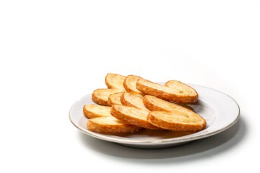 Kelebek Puf Böreği ya da Palmier Kurabiyeleri, beyaz arka planda izole edilmiş bir tabakta kalp şeklinde.