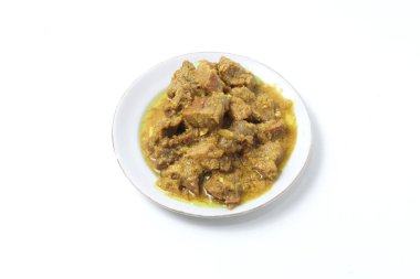 Yellow spiced beef, made with shallots, turmeric, and candlenuts, on a plate isolated on white background