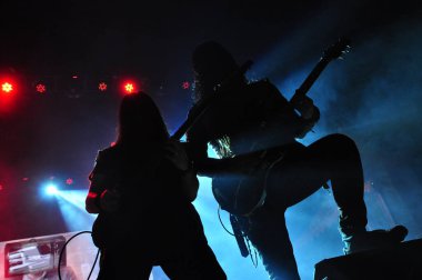 Gitarist silueti sahnede. Koyu arkaplan ve duman