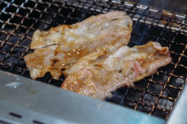 Barbekü ızgarasında çiğ et kızartılıyor.