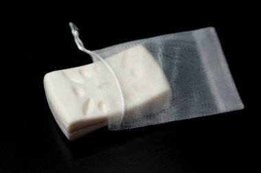Siyah arkaplanda izole edilmiş ağ torbasındaki sabun