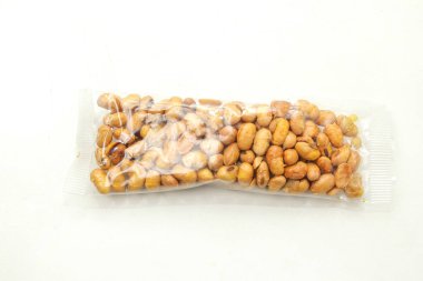 Beyaz arka planda plastik ambalajda kızarmış soya fasulyesi atıştırmalıkları.