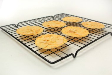 Izgara peynirli badem çıtır kurabiyeler, ince desenli, beyaz arka planda izole edilmiş.