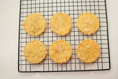 Izgara peynirli badem çıtır kurabiyeler, ince desenli, beyaz arka planda izole edilmiş.