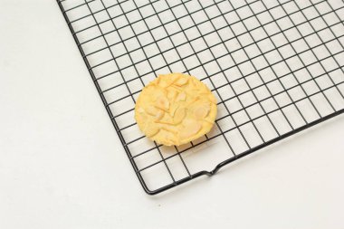 Izgara peynirli badem çıtır kurabiyeler, ince desenli, beyaz arka planda izole edilmiş.