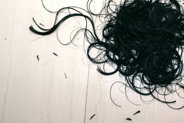 Yerde siyah saçlar var.