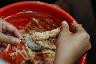 Satay için şişlere hamur yapıştıran elleri kapatın.