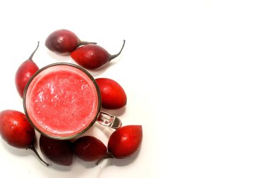Bir bardakta tamarillo suyu ve yanında da beyaz bir arka planda izole edilmiş tramarillo.