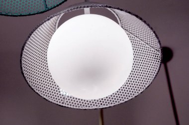 Tavandan sarkan modern küresel bir lamba, minimalist bir iç mekanı aydınlatıyor..