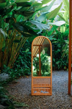 Ayna bahçenin arka planında duruyor.