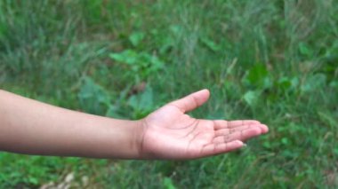In the era of Covid-19, washing hands is more important than ever.  This video shows an American American man using hand sanitizer to clean his hands at a local park.  