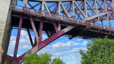 This video shows a view of the Hell Gate bridge in Bronx, NY.  The Hell Gate Bridge is a 1,017-foot steel through-arch railroad bridge in New York City.